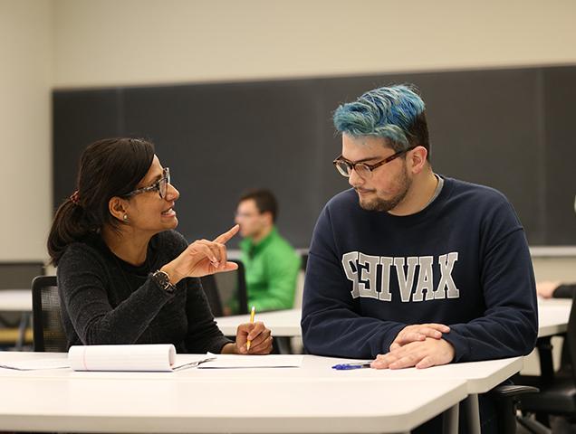 一个学生和教授在桌子前讨论一个想法